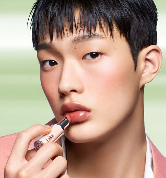 A model applying Laka Bonding Glow Lipstick for a glossy finish showcasing luxurious colors.