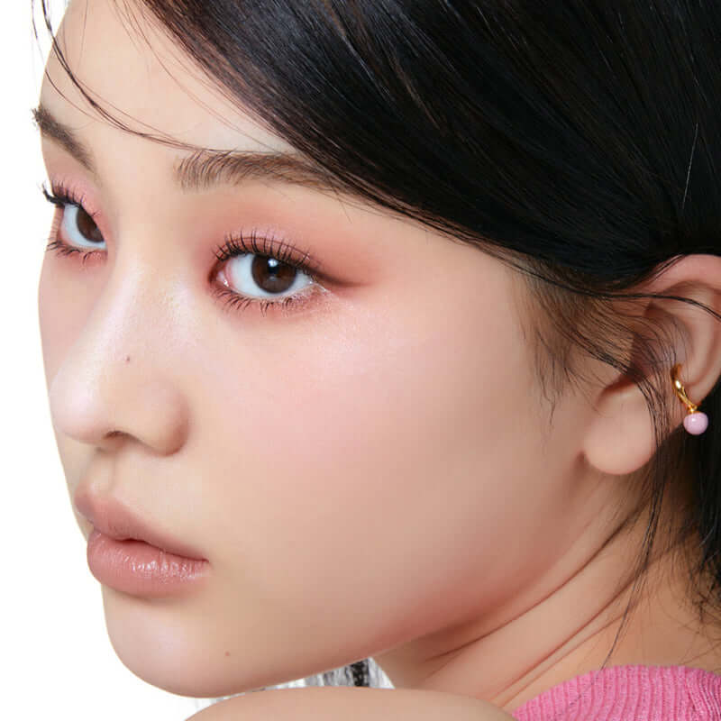 Close-up of a model showcasing radiant skin with Laka Dreambeam highlighter for a glowing makeup look.