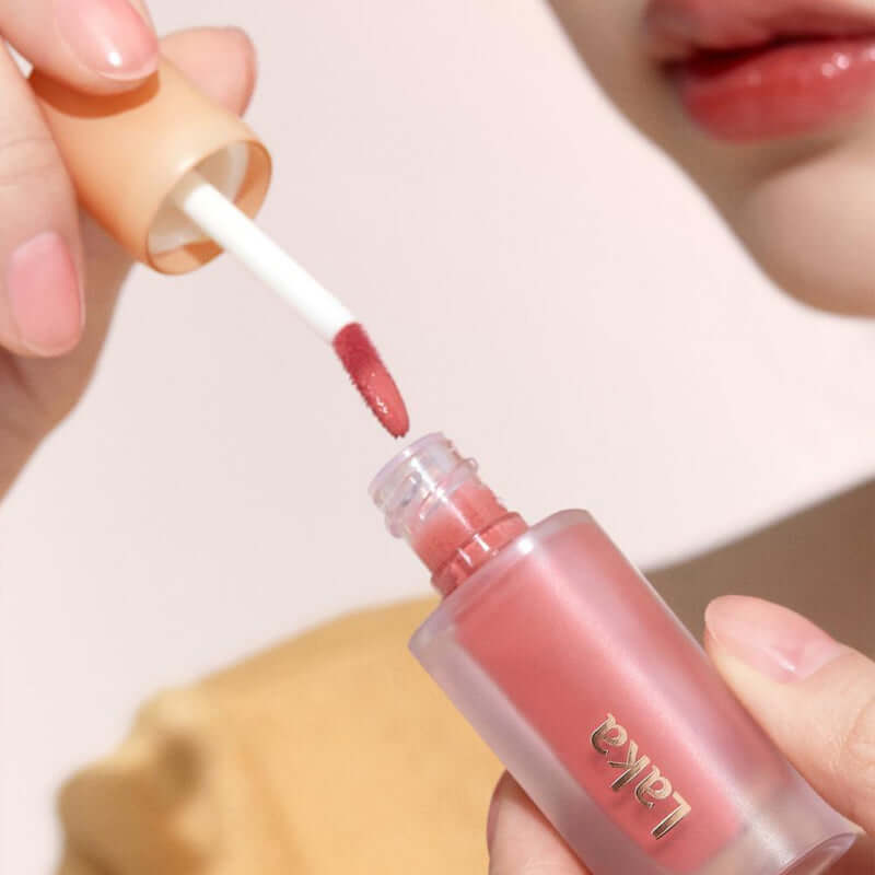 Applying Laka Fruity Glam Tint with a doe-foot applicator, showcasing the juicy color and glossy finish.