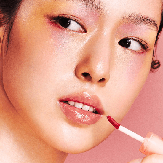 Model applying Laka Jelling Nude Gloss, showcasing shiny, hydrated lips with a Y2K-style lip tint.