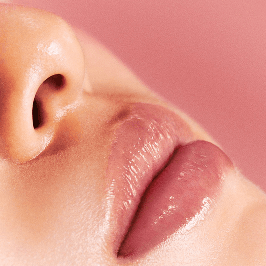 Laka Jelling Nude Gloss on lips, showcasing a shiny and hydrating gel-oil texture for a sassy Y2K style.