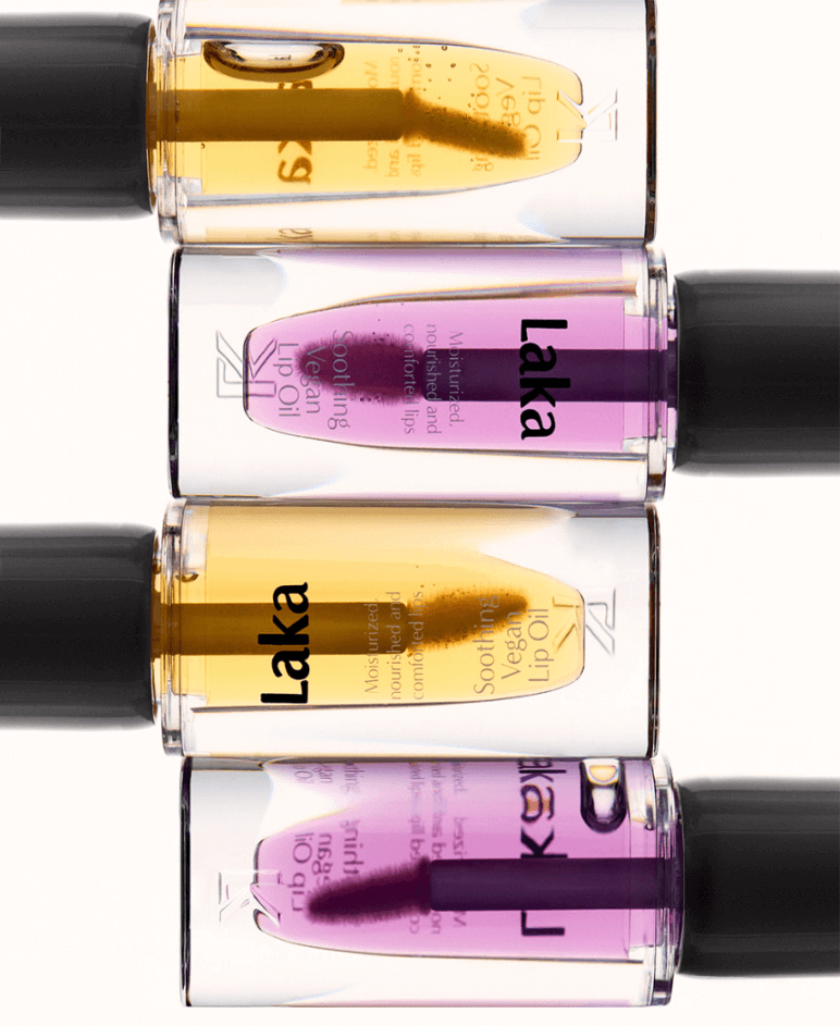 Three Laka Soothing Vegan Lip Oils in yellow and purple bottles, showcasing moisturizing lip care options.