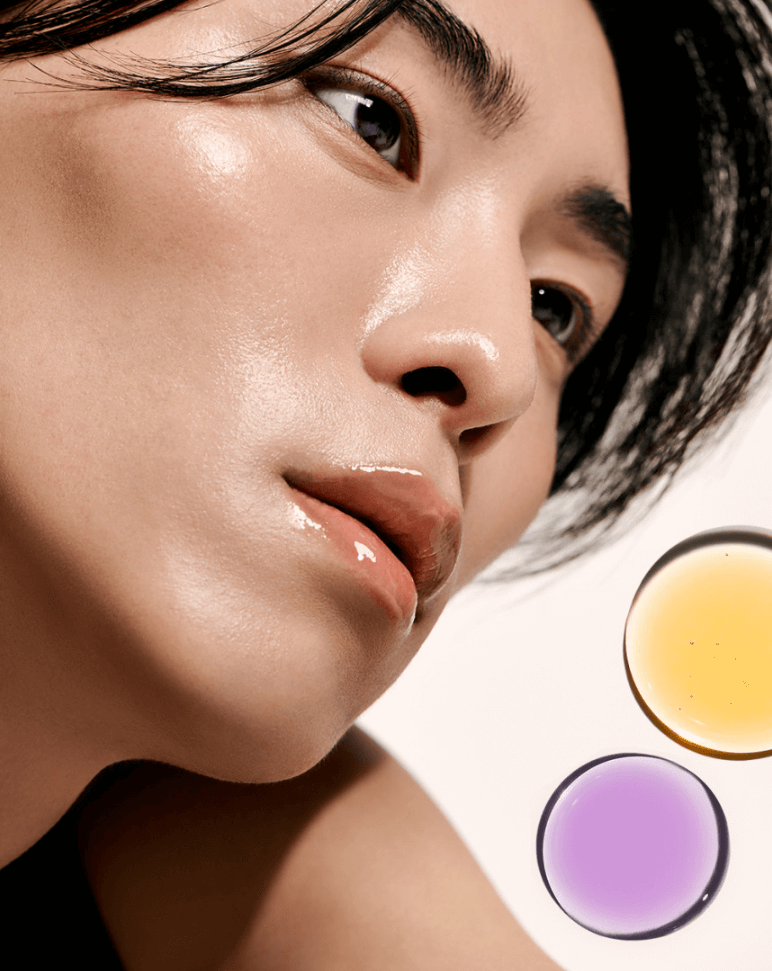 Model showcasing radiant skin with Laka Soothing Vegan Lip Oil in calming purple and yellow tinted oils.