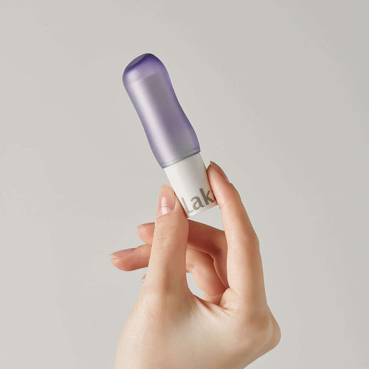 Laka Soul Vegan Lip Balm in futuristic packaging, held in a hand, showcasing tinted lip balm for hydration.