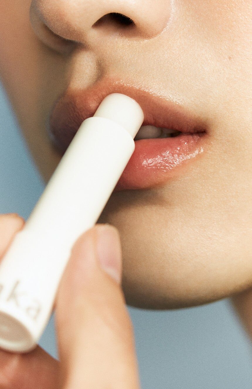 Model applying Laka Soul Vegan Lip Balm, featuring gender-neutral packaging and hydrating formula.