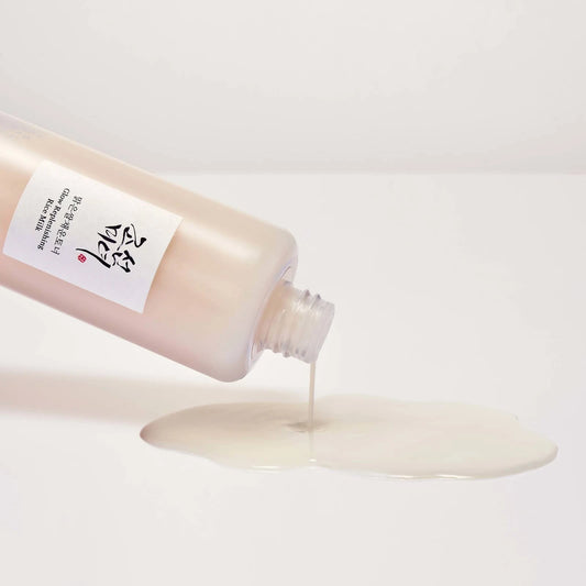 Beauty of Joseon Glow Replenishing Rice Milk cascading from a bottle, showcasing its hydrating dual-layer formula.